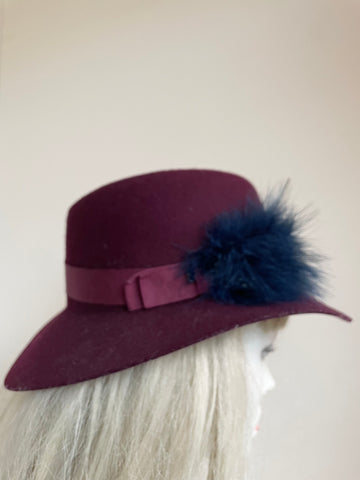 UNBRANDED BURGUNDY FELTED WOOL HAND TRIMMED TRILBY HAT WITH NAVY FEATHERS SIZE APPROX S/M