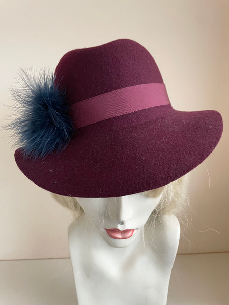 UNBRANDED BURGUNDY FELTED WOOL HAND TRIMMED TRILBY HAT WITH NAVY FEATHERS SIZE APPROX S/M